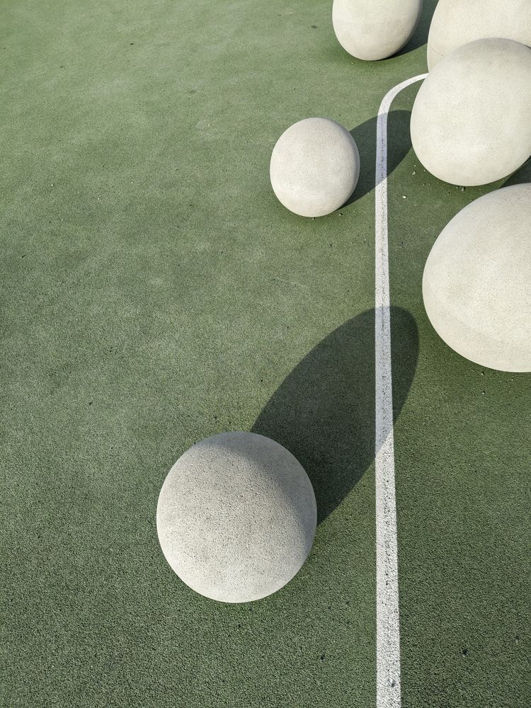 Runde Steinsitze auf einem grünen Sportplatz