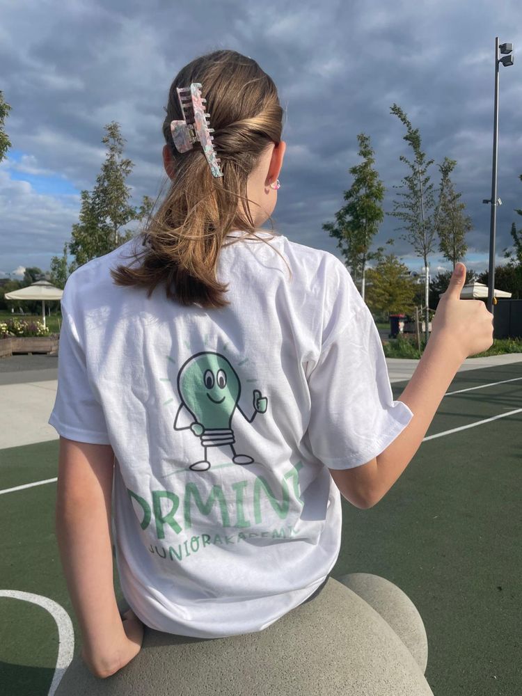Schülerin im Dr.-Mint-T-Shirt, von hinten, mit Daumen hoch